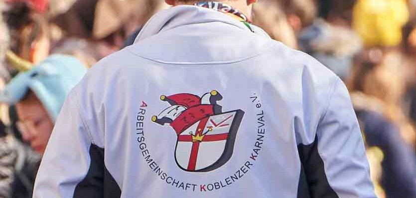 Mann mit Narrenkappe und Jacke mit Rückendruck "Arbeitsgemeinschaft Koblenzer Karneval" Mann mit Narrenkappe und Jacke mit Rückendruck "Arbeitsgemeinschaft Koblenzer Karneval"