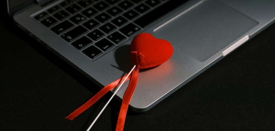 Notebook mit darauf liegendem Herzstecker Notebook mit darauf liegendem Herzstecker