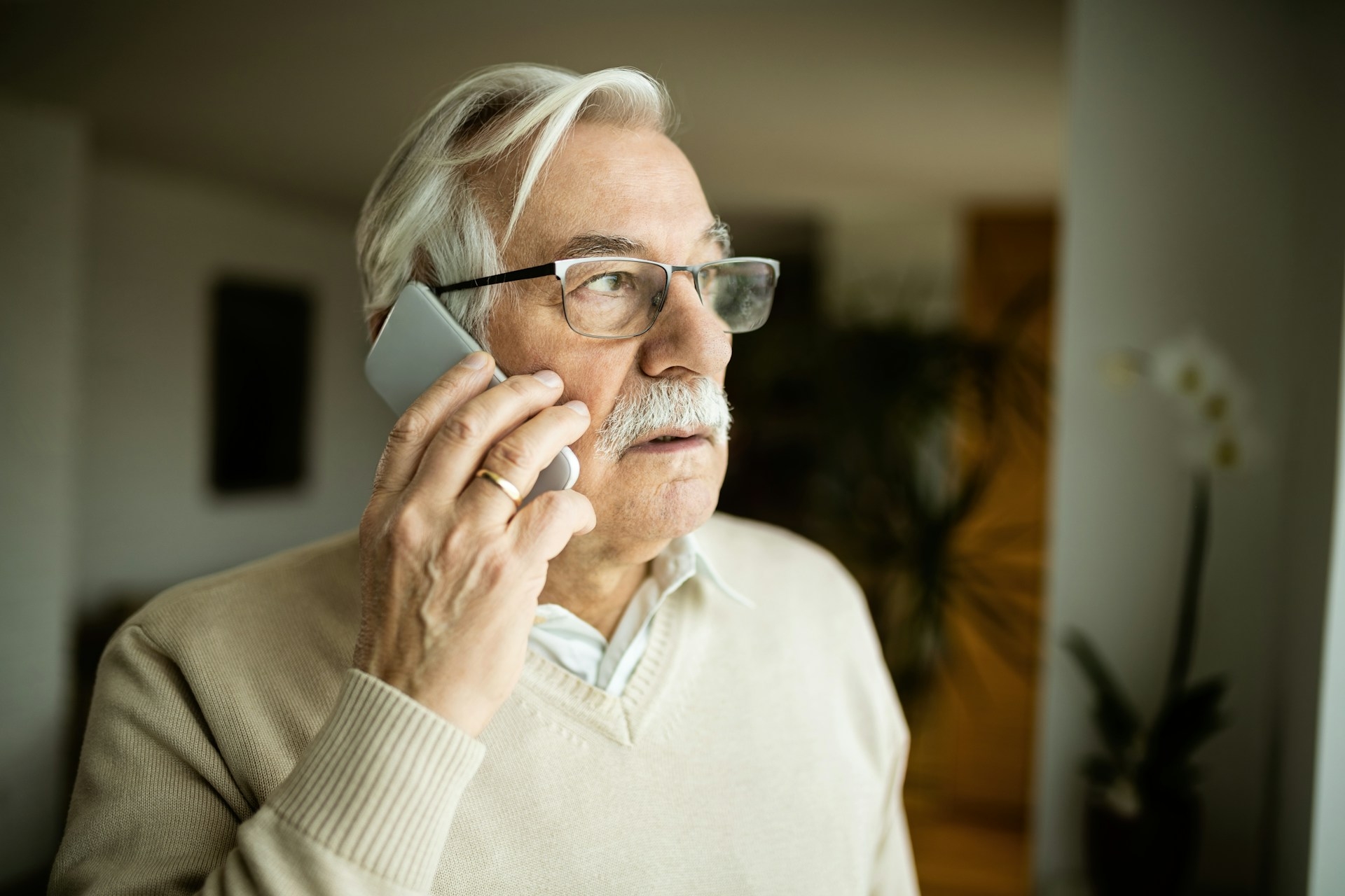 Ein Senior telefoniert mit Smartphone.