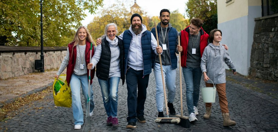 Eine Gruppe zieht mit Besen und Müllsack los zum Säubern. Eine Gruppe zieht mit Besen und Müllsack los zum Säubern.