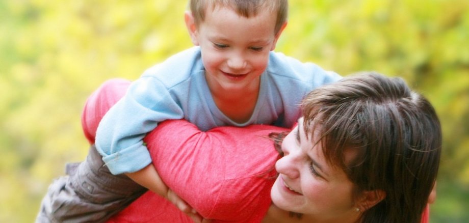 Pflegemutter mit Kind Pflegemutter mit Kind - welches sie Huckepack trägt