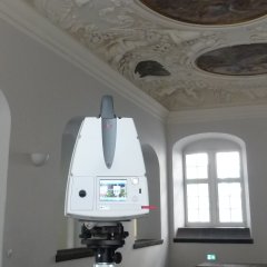 zeigt das Messgerät zum Laserscannig im Rathaussaal stehend