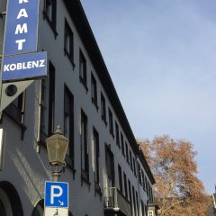 Aussenfassade des bürgeramtes mit Eingangsbereich im Vordergrund und große Linde vor dem Rathaus im Hintergrund