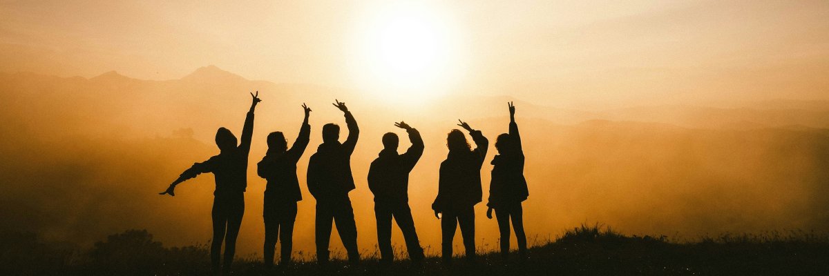 Sechs Personen vor einem Sonnenuntergang