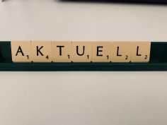 Scrabble-Buchstaben bilden das Wort "Aktuell".