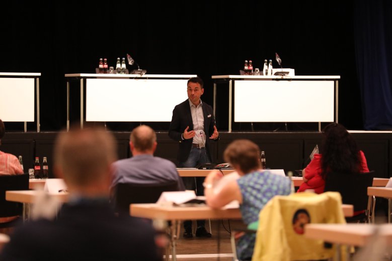 Gremiensitzung - Blick aus Rücken der Teilnehmenden auf Redner