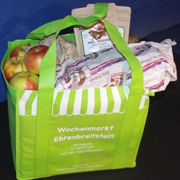 Markttasche gefüllt mit Brot, Äpfeln, Gewürzen vom Wochenmarkt.