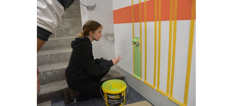 Caroline Bornemann beim Streichen der Wänder in der Malerwerkstatt. Caroline Bornemann beim Streichen der Wänder in der Malerwerkstatt.