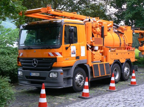 Orangenes Kanalreinigungsfahrzeug der Stadt Koblenz, mit Signalkegeln umstellt