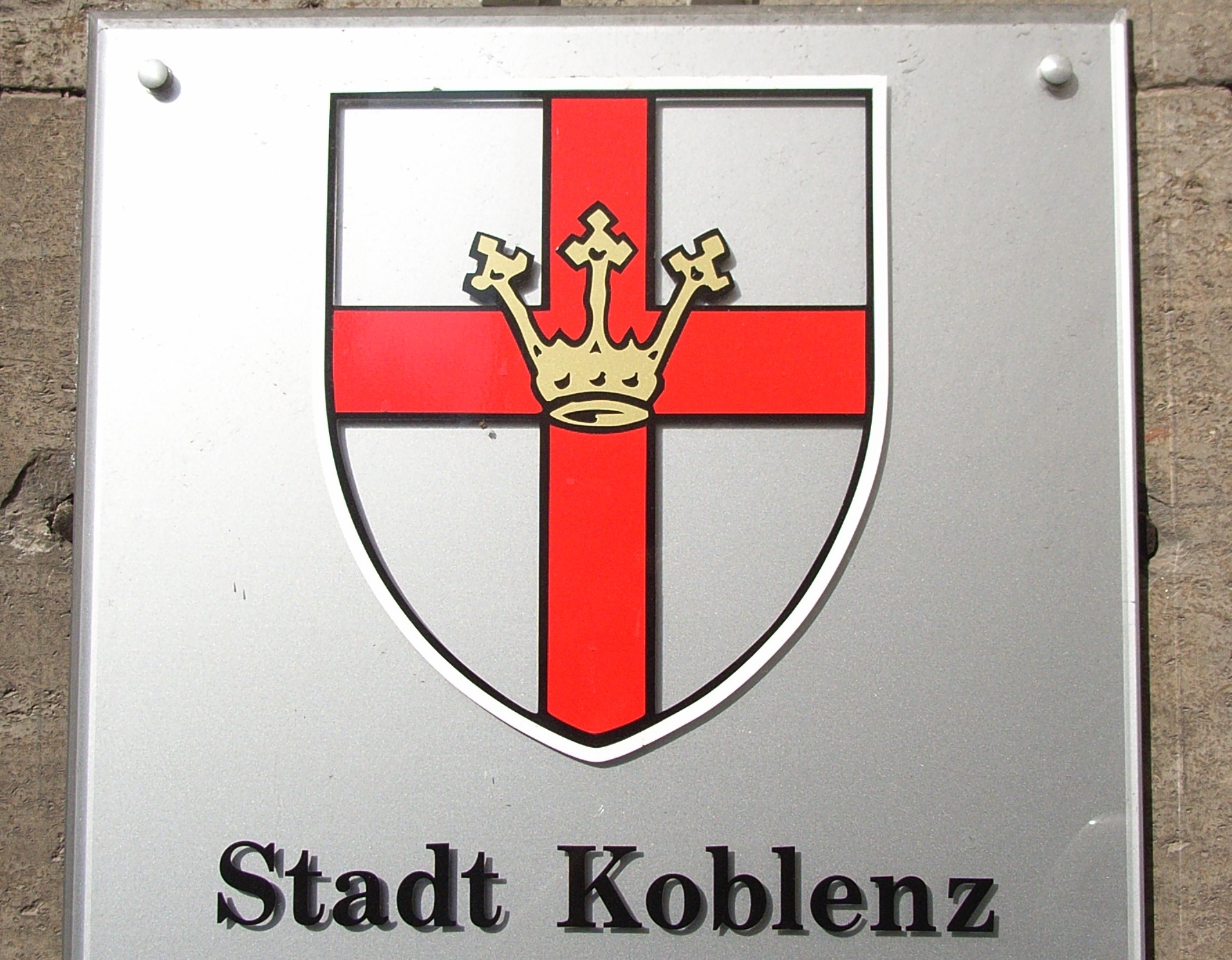 Schild mit Wappen der Stadt Koblenz - an Wand angebrachtes Schild mit dem Koblenzer Stadtwappen - goldene Krone über einem roten Kreuz auf silbernem Grund - und Schriftzug "Stadt Koblenz"