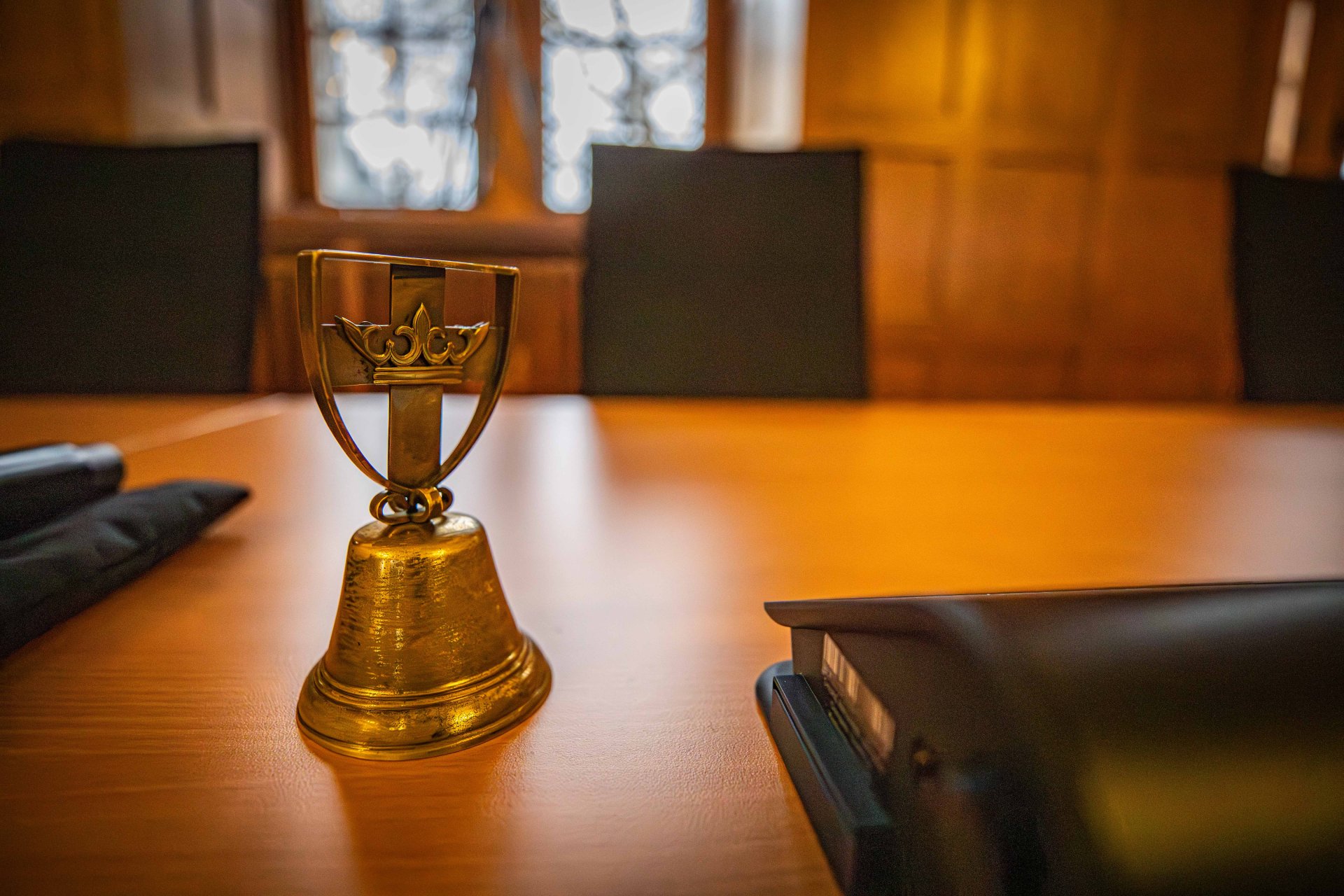 Eine Handglocke steht auf einem Tisch.