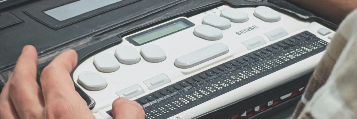 Finger liegen auf Braille-Tastatur "Sense" 