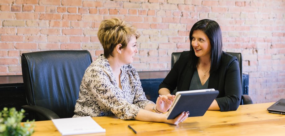 Berufliche Beratung Berufliche Beratung - eine Frau berät eine andere Frau im beruflichen Umfeld.
