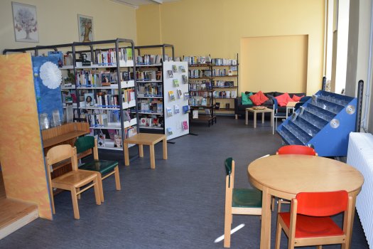 Blick in die Erwachsenenabteilung der Stadtteilbücherei Horcheim mit Regalen, Lesekiste und Sitzgelegenheiten.