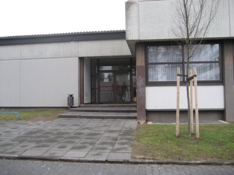 Außen-/Fassadenansicht der Stadtteilbücherei Karthause in der Grundschule Neukarthause. Man sieht den Eingang.