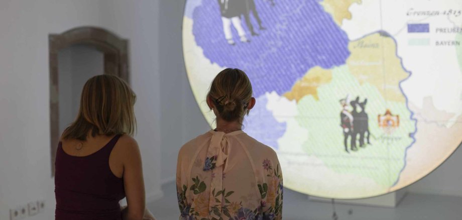 Zwei Besucherinnen des Kandesmuseums vor einer Projektion Zwei Besucherinnen des Kandesmuseums vor einer Projektion