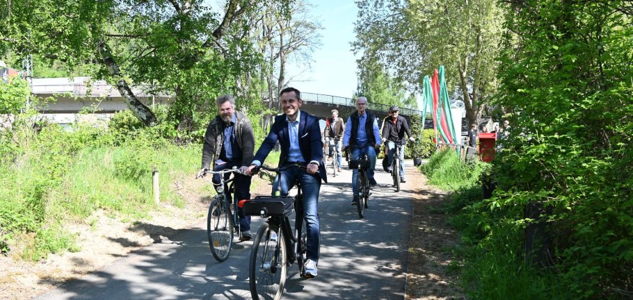 Mehrere Menschen radeln auf einem Radweg.
