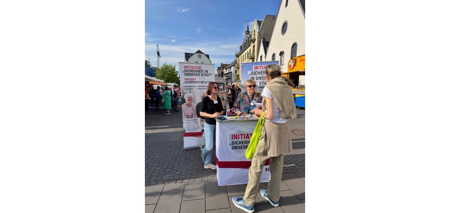 3 Personen an einem Informationsstand.