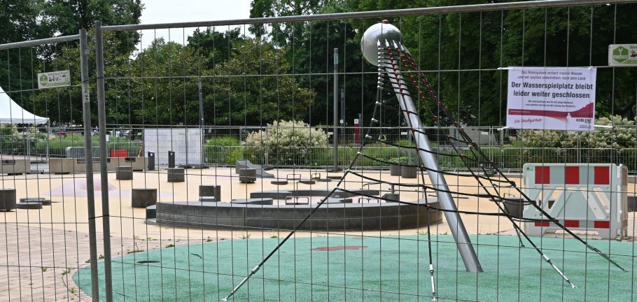 Ein Spielplatz, der durch einen Bauzaun abgesperrt ist.