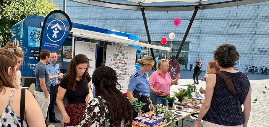 Ein Infostand mit Menschen im gemeinsamen Gespräch.
