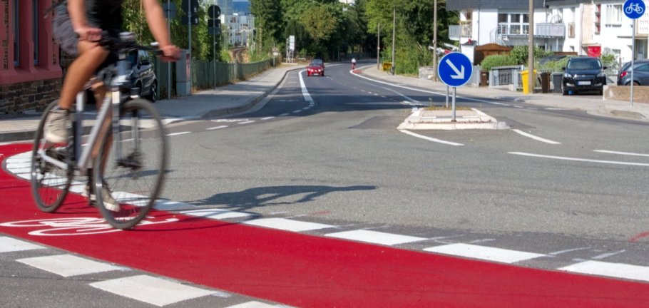 Ein Radfahrer auf einem Radweg fährt durch eine Kurve.