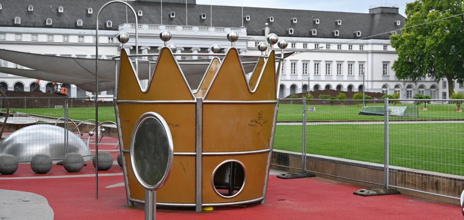 Die Krone der Kaiserin Augusta muss saniert werden und bleibt vorerst eingezäunt. Der Boden des Kletterturms ist morsch. Eine überdimensionale Krone steht auf einem Spielplatz. Der Spielplatz ist mit Bauzäunen umstellt.