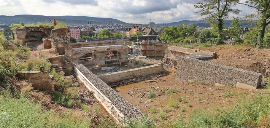 Eine Baustelle. Im Hintergrund alste Festungsmauern, die eingerüstet sind.