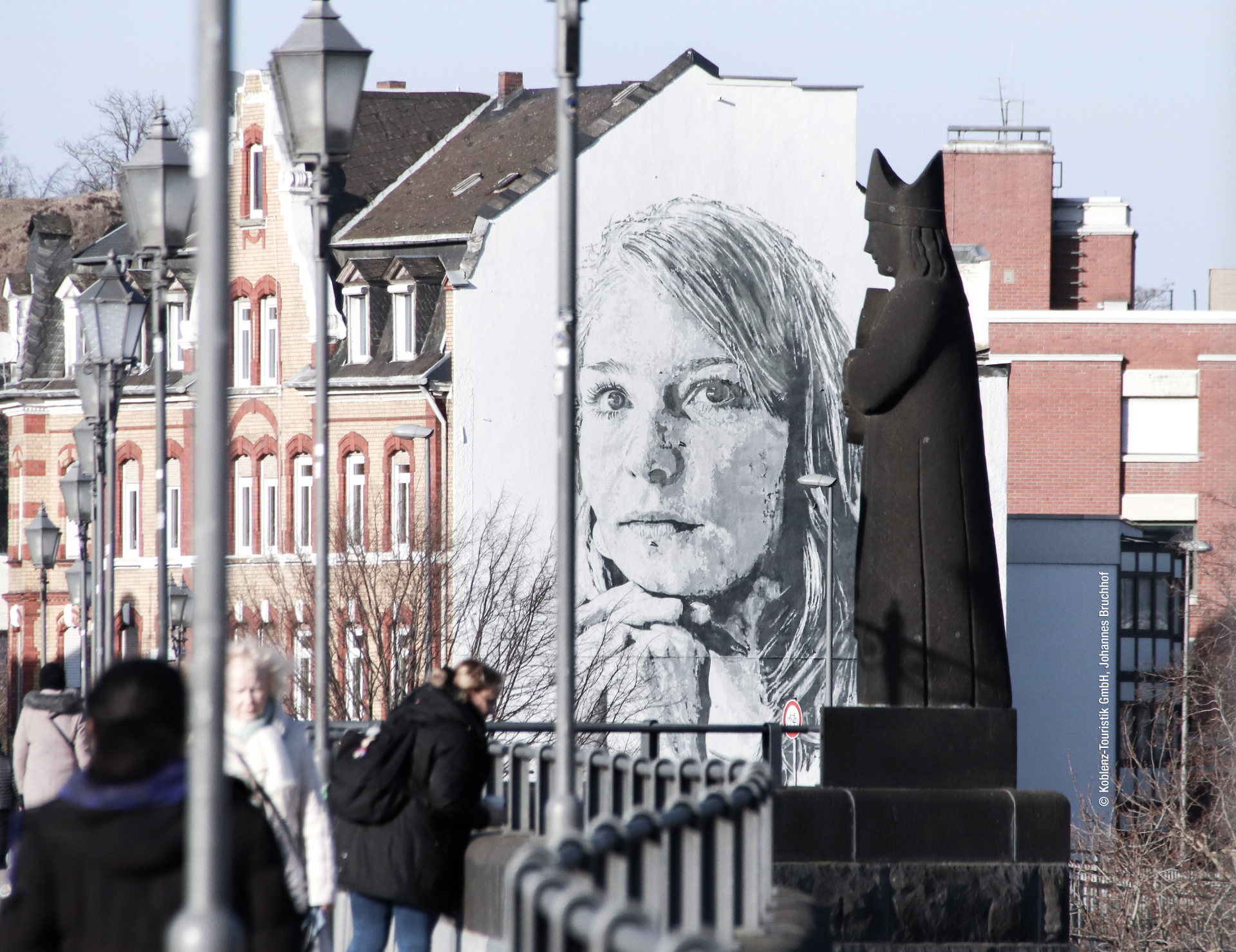 Ein Gebäude des Giebelwand mit einem Mädchen-Porträt bemalt wurde.
