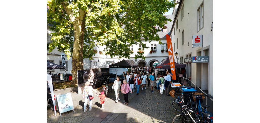 Markttreiben mit Ständen und dazwischen viele Menschen.