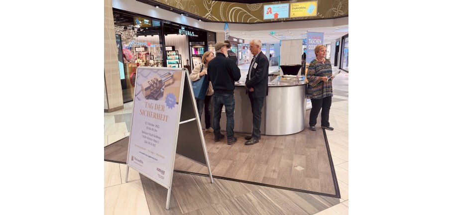 Menschen stehen an einem Stand in einem Einkaufszentrum.