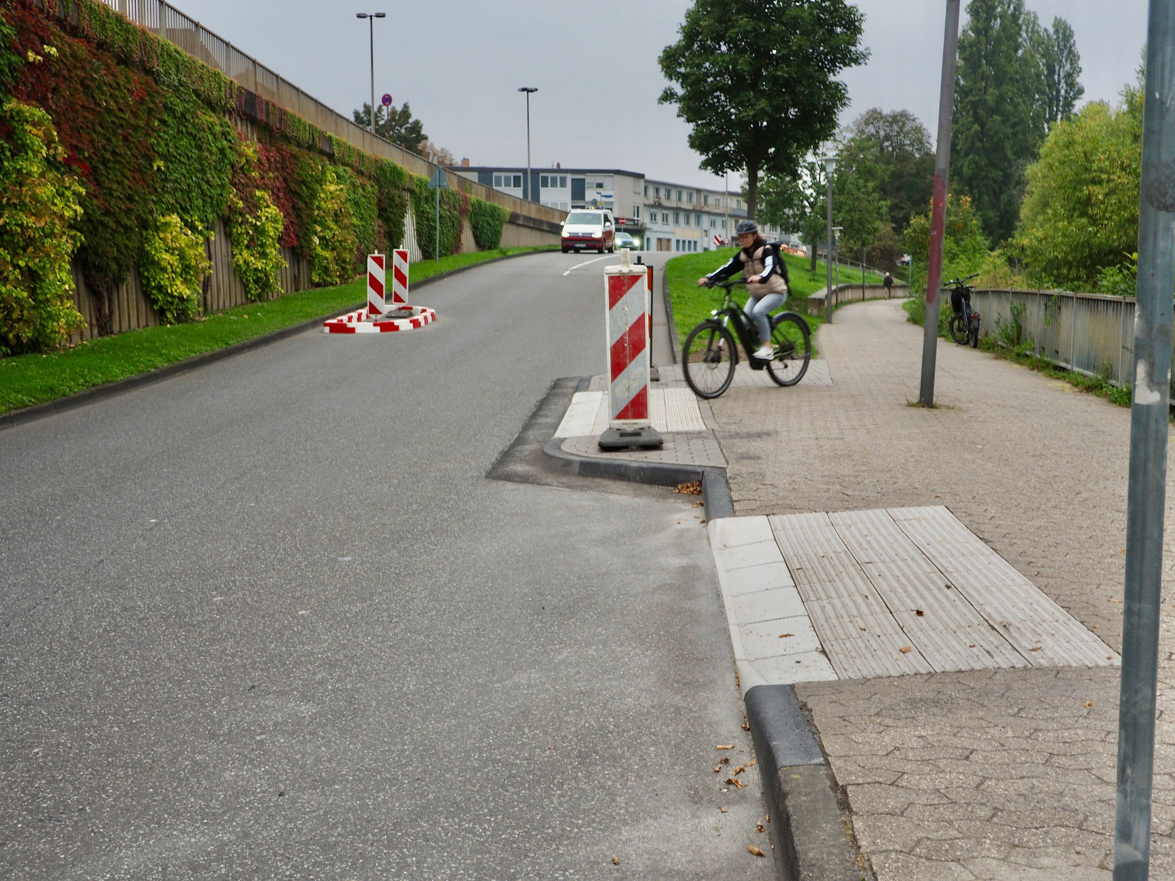 Eine Radfahrerin nutzt eine neu geschaffene Ausleitung vom Rad-Gehweg auf die Straße.