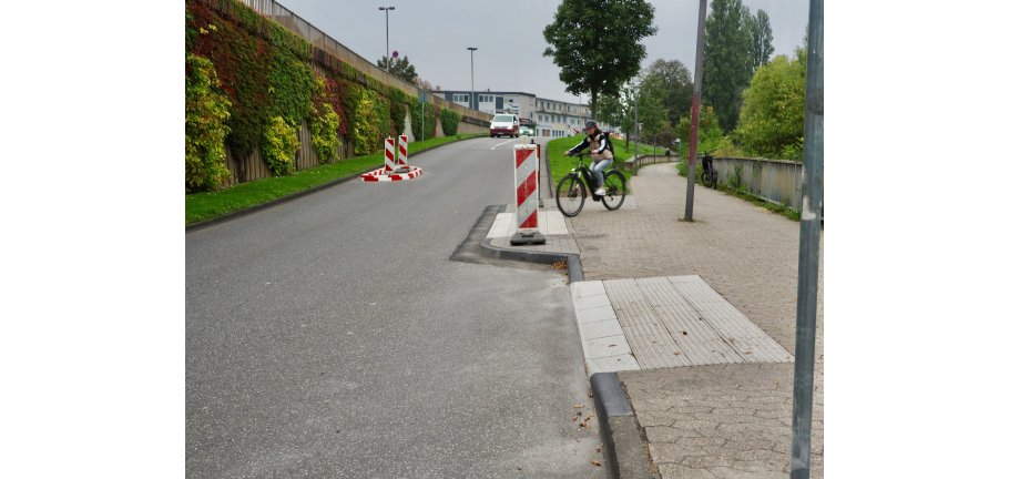 Eine Radfahrerin nutzt eine neu geschaffene Ausleitung vom Rad-Gehweg auf die Straße.