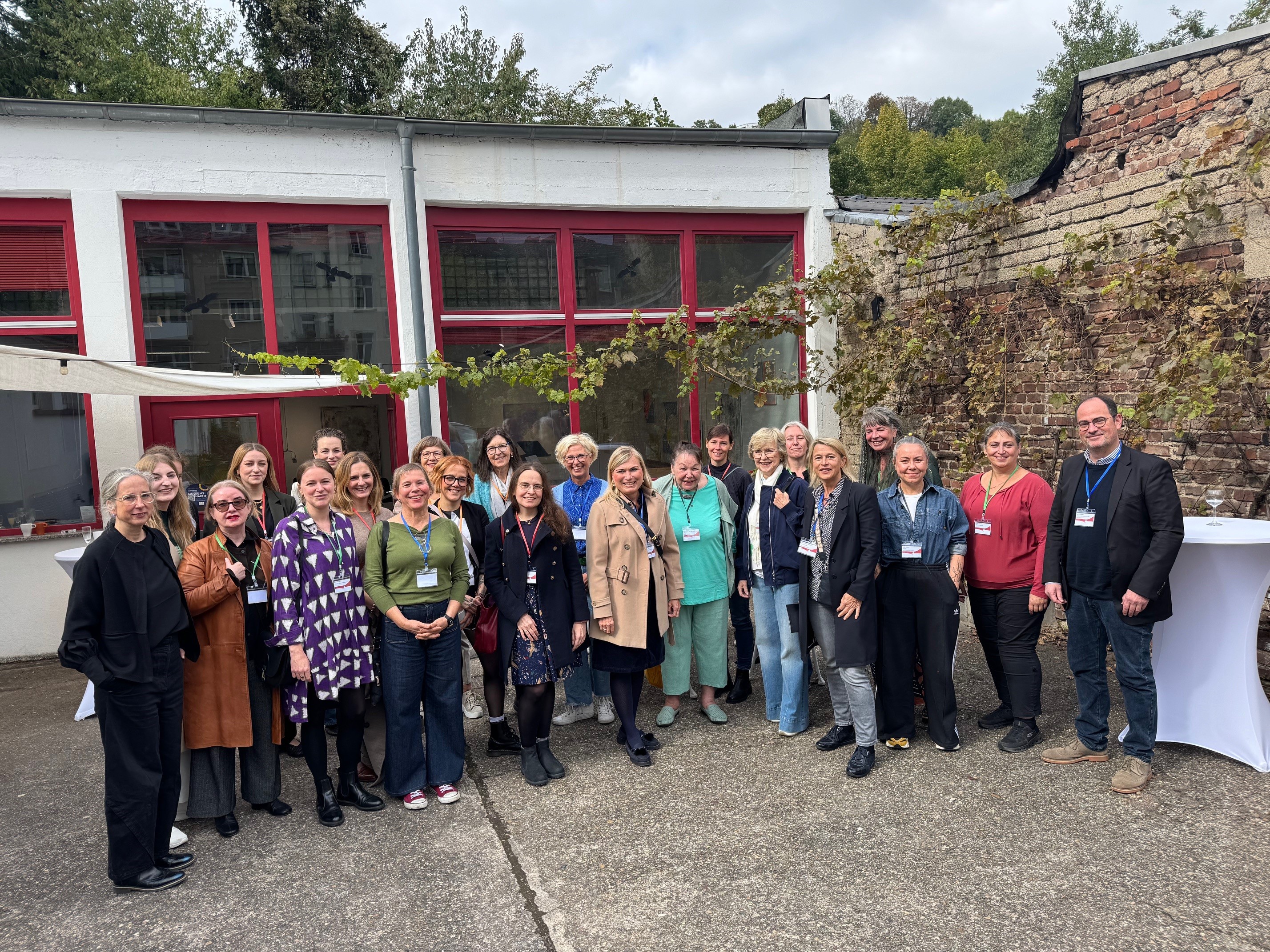 Ein Mann und viele Frauen vor einem Gebäude.