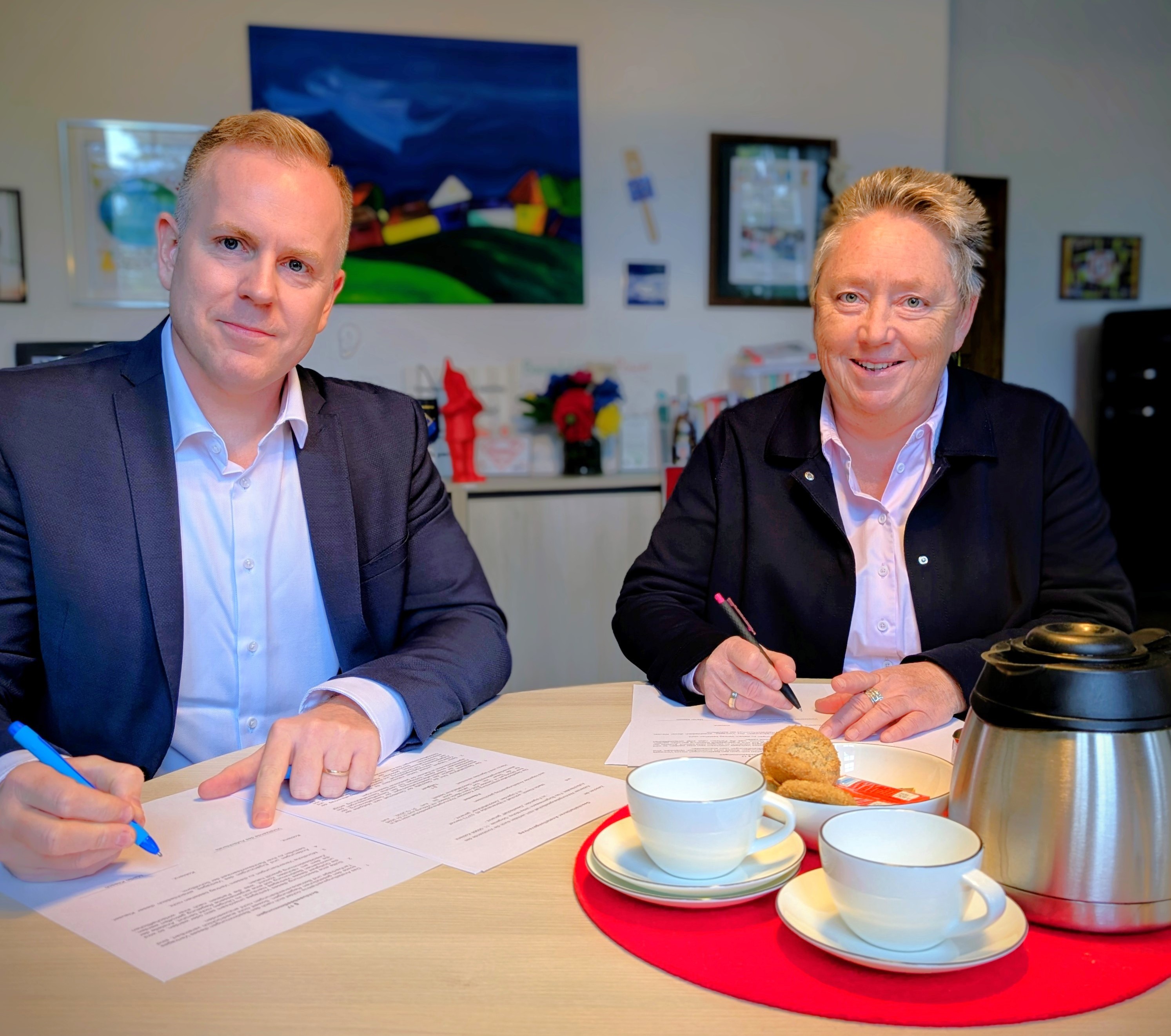 Ein Mann und eine Frau an einem Tisch sitzend.