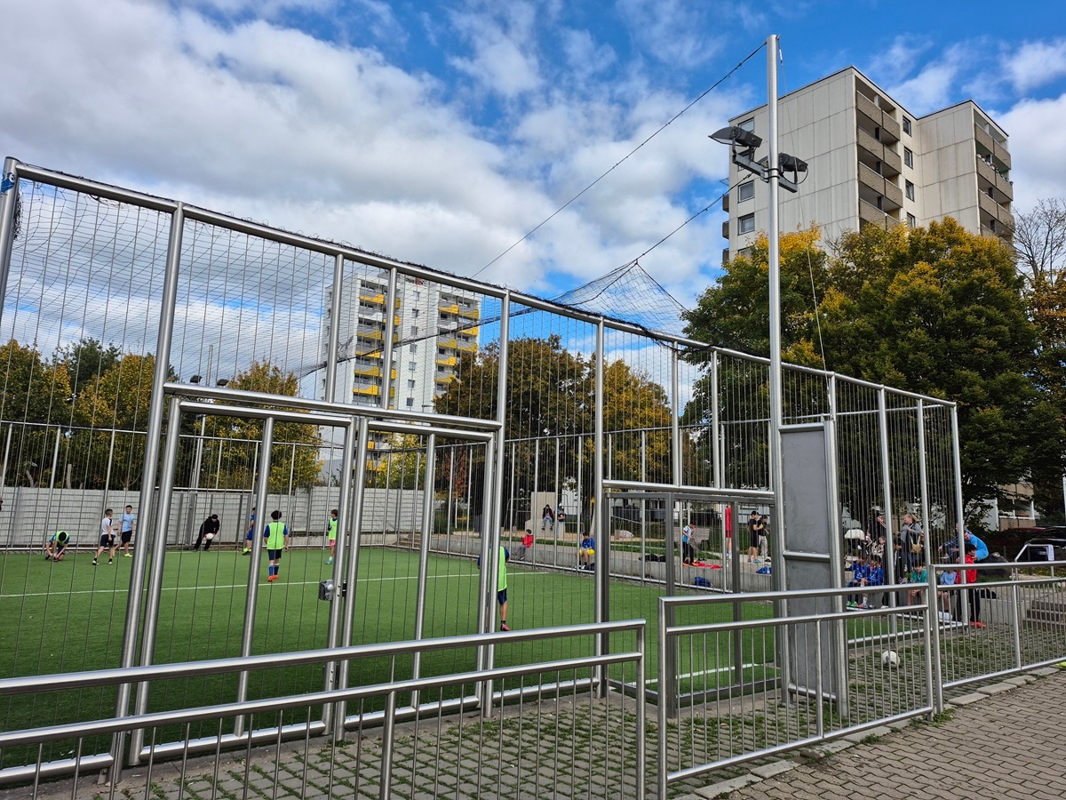 Kinder spielen in einem Soccer Cage.