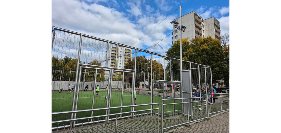 Kinder spielen in einem Soccer Cage.