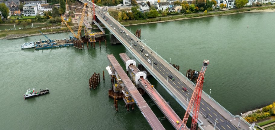Aus der Vogelperspektive lässt sich bereits der Verlauf der neuen Pfaffendorfer Brücke in der Parallellage erkennen. Aus der Vogelperspektive ist eine Brückenbaustelle im Rhein zu erkennen.