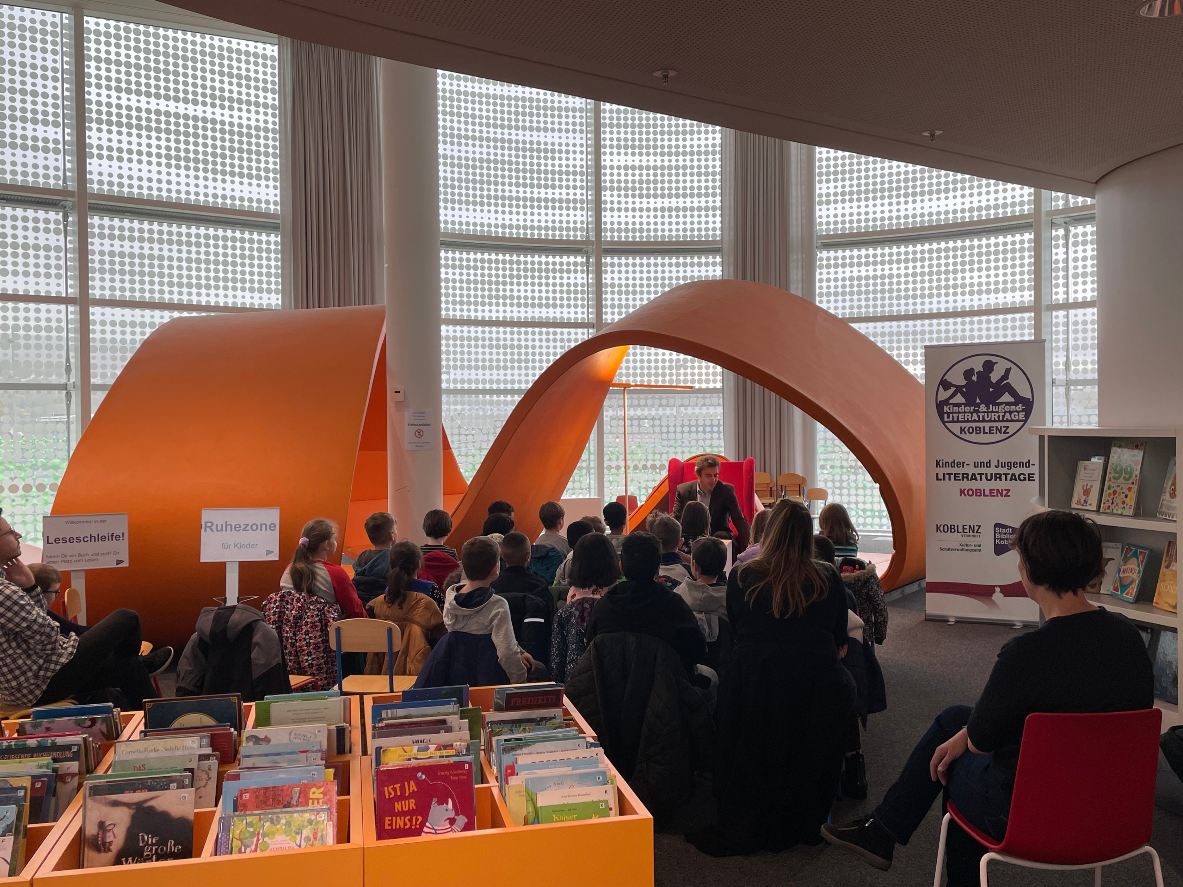 Ein Erwachsener liest Kindern vor.