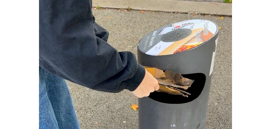 Ein öffentlicher Abfallbehälter wird befüllt.