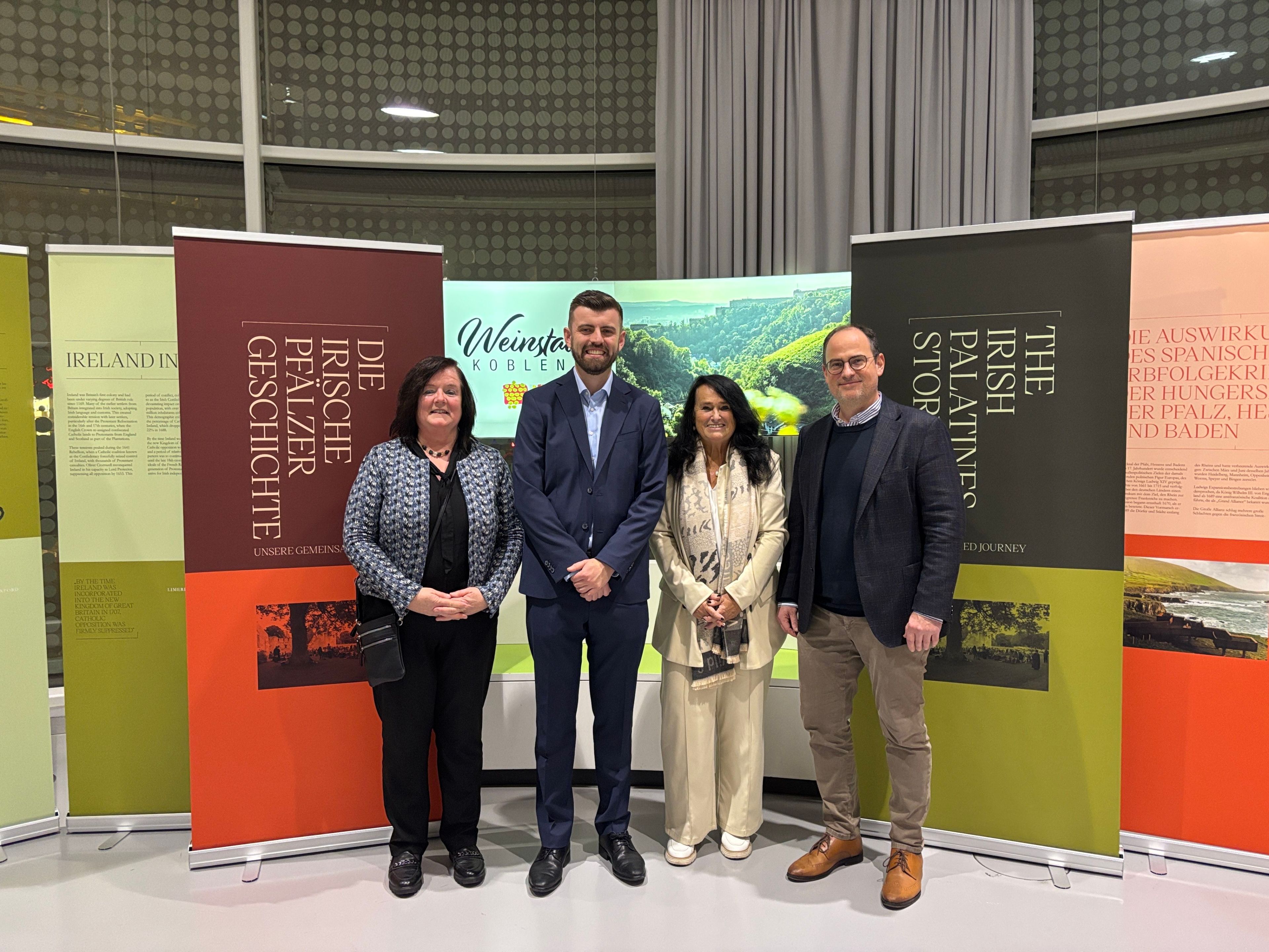 4 Personen stehen vor Ausstellungs-Roll-ups.