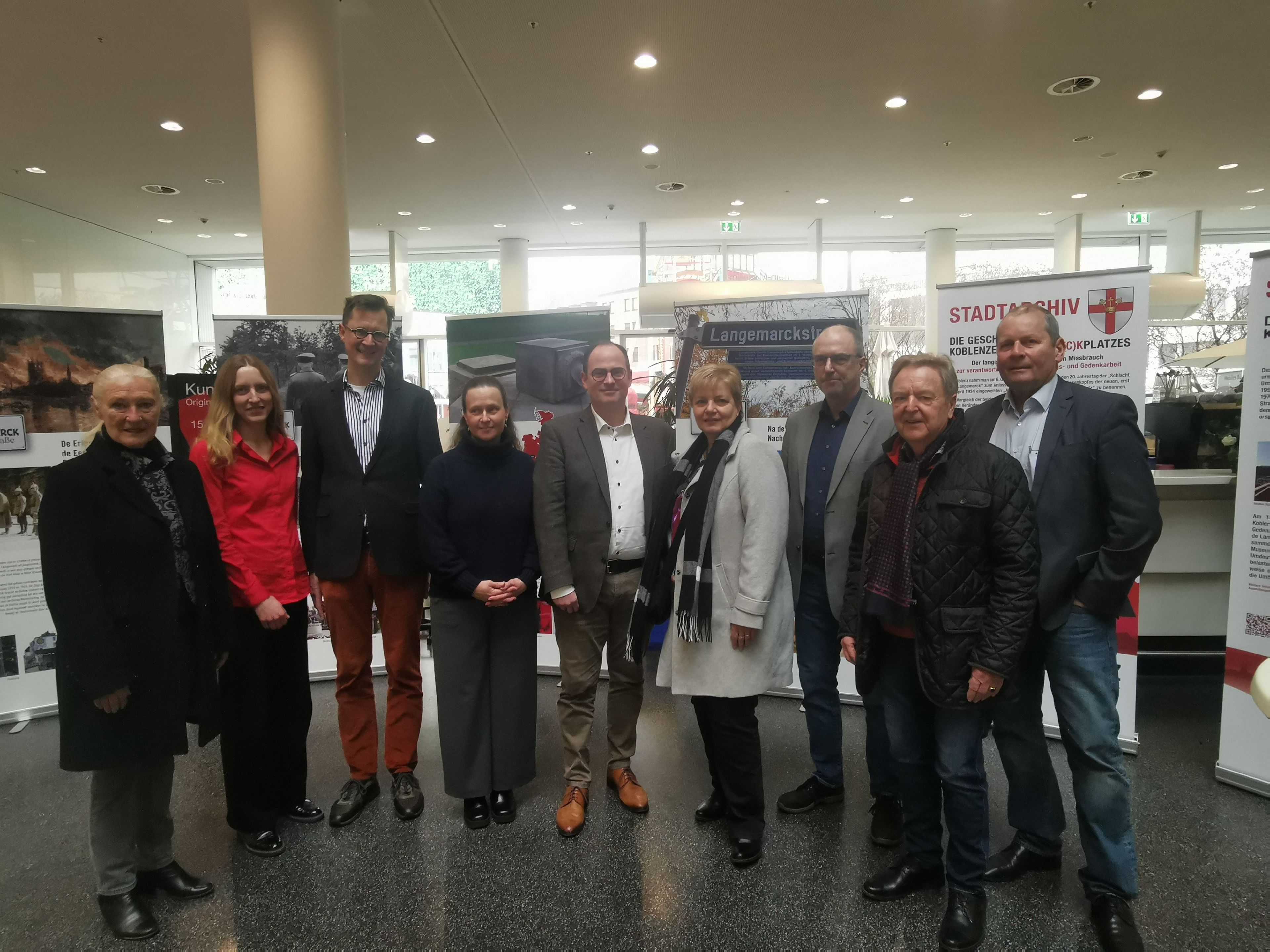 Neun Personen stehen vor Ausstellungs-Roll-ups.