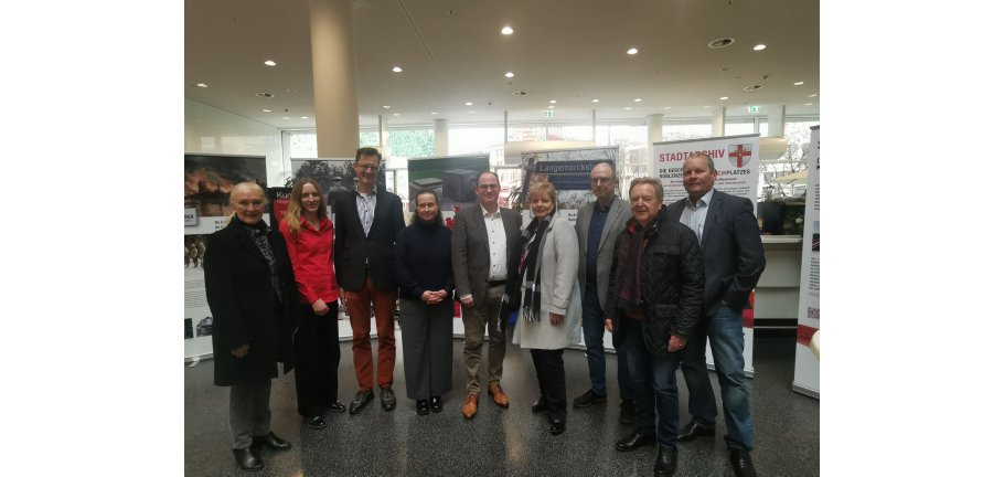 Neun Personen stehen vor Ausstellungs-Roll-ups.