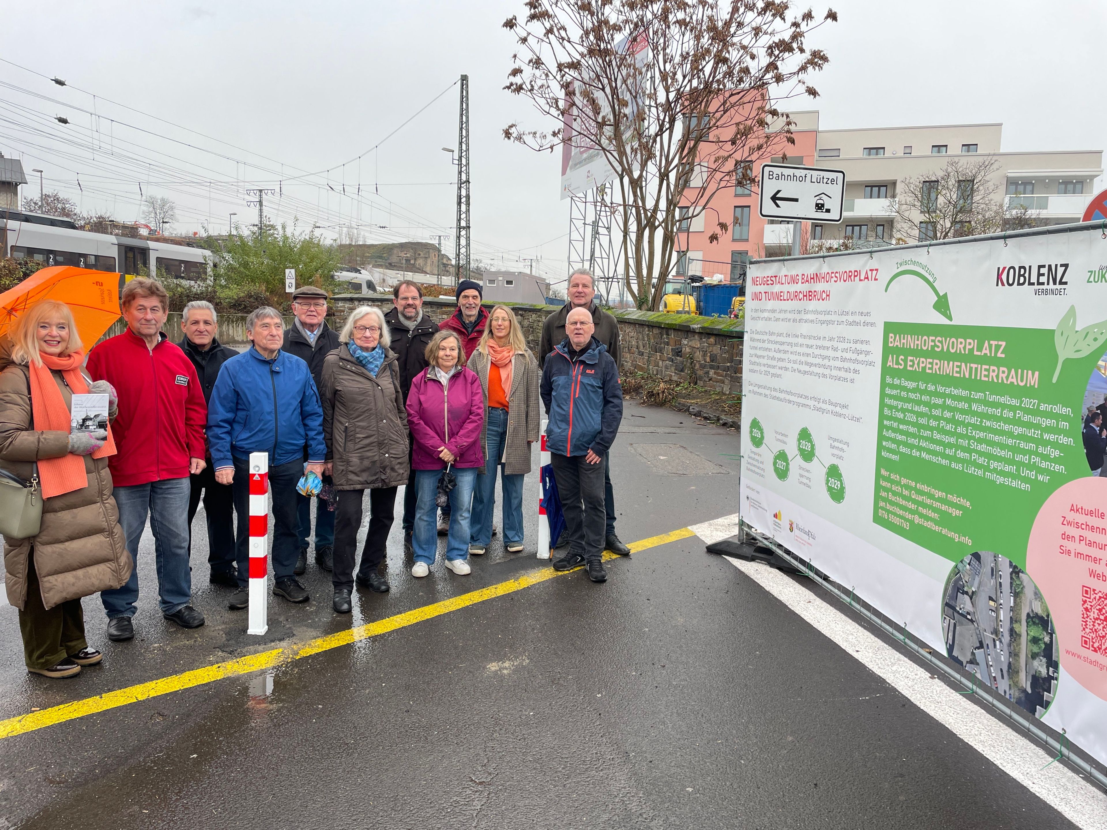 Viele Menschen neben einem Bauzaunbanner.