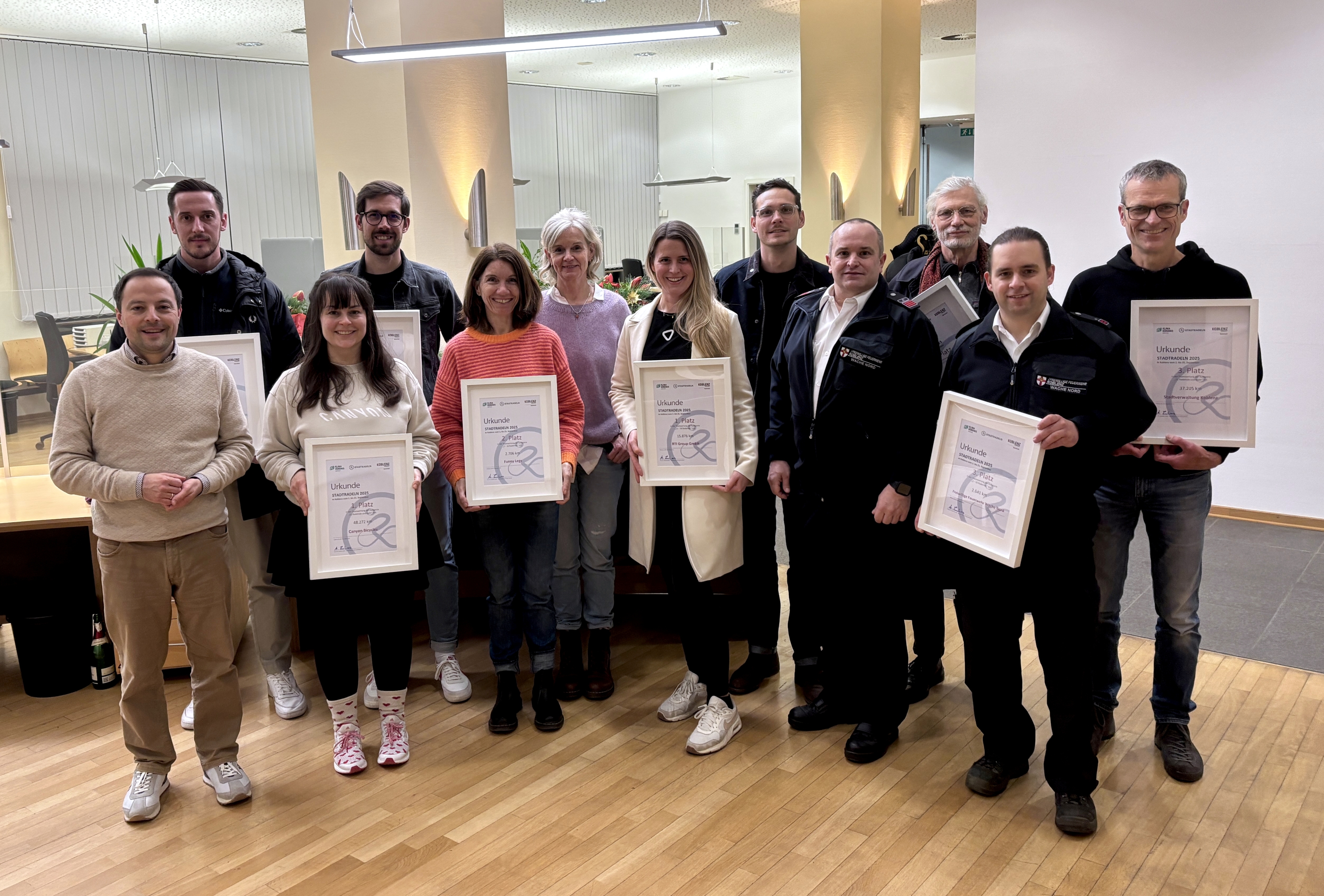 Viele Menschen zum Teil gerahmte Urkunden haltend.