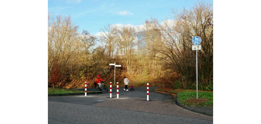 Eine Einfahrt ist mit rot-weißen-Pollern so verschlossen, dass Autos dort nicht mehr einfahren können.