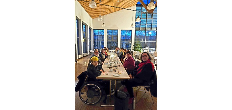 Viele Menschen an einer langen Tafel.