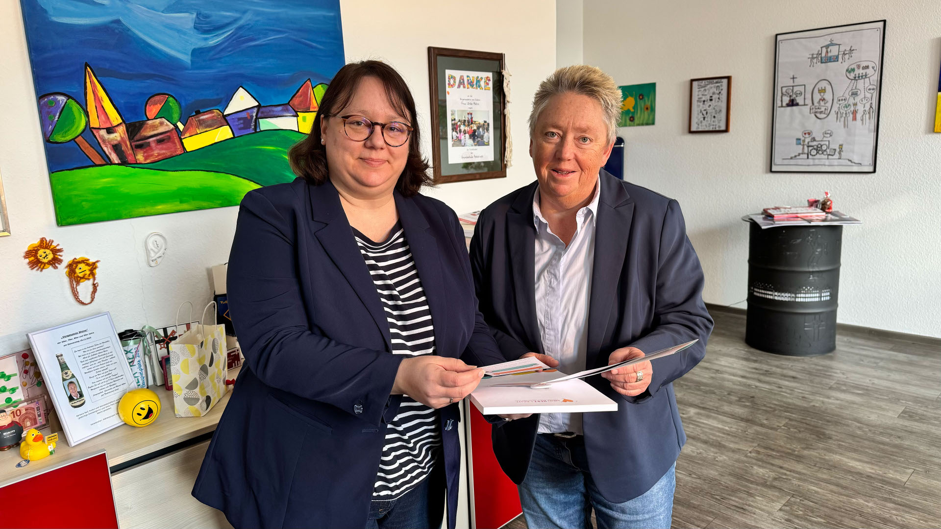 Zwei Frauen stehen in einem Raum und tauschen sich aus.