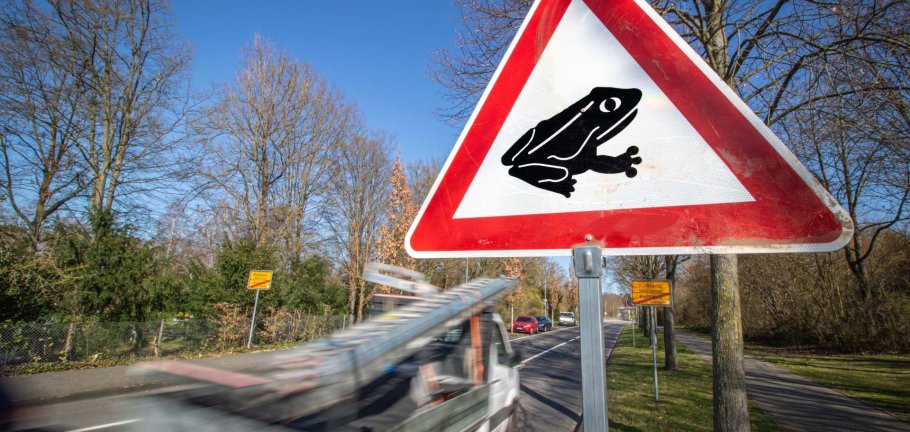 Ein Warnschild zeigt einen Frosch Ein Warnschild zeigt einen Frosch
