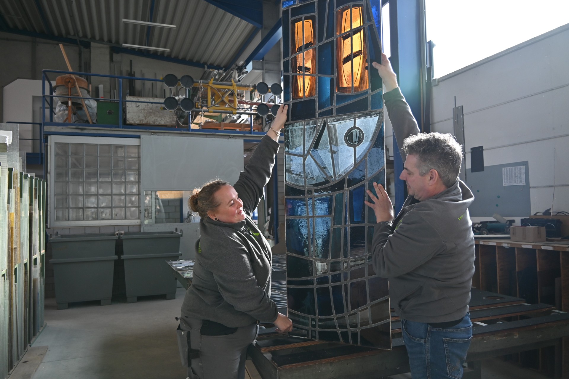 Ingo Caspary und Lena Bentley begutachten das Buntglasfenster, das Dank der Koblenzer Kultur Stiftung einen neuen Platz in der Kapelle des Bezirksfriedhofs Metternich bekommt.