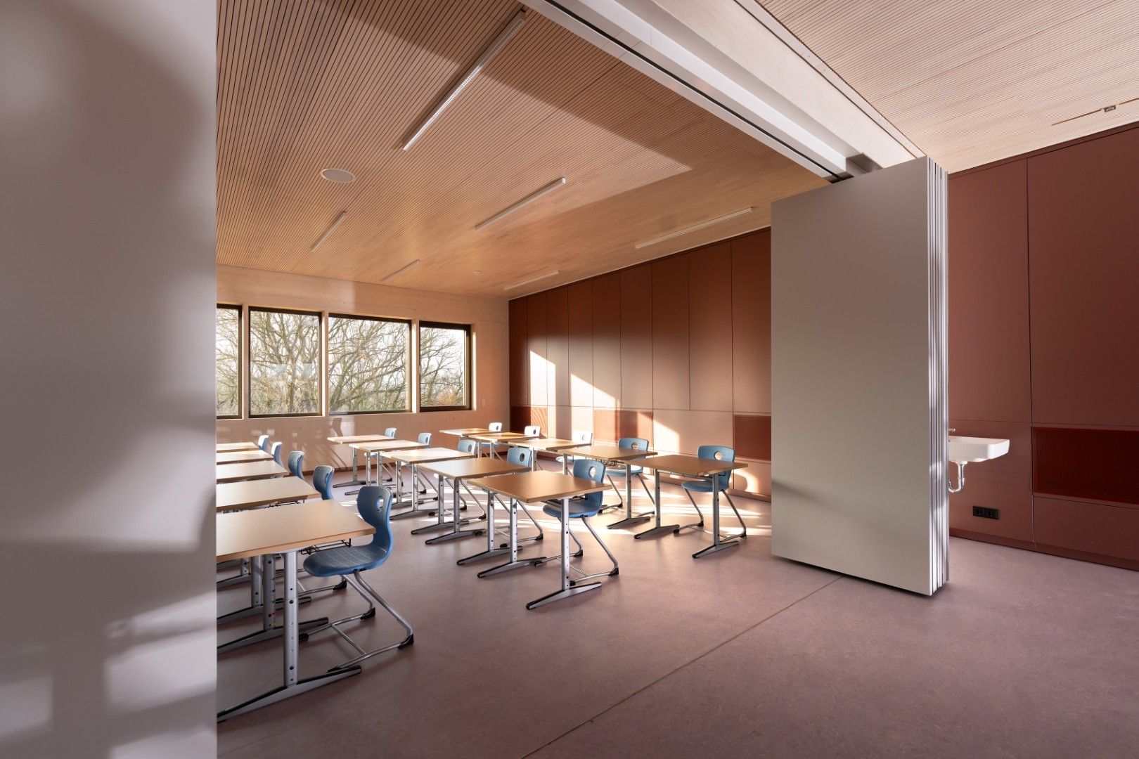 Sonnenlicht fällt durch Fenster in einen modernen Klassenraum ein.